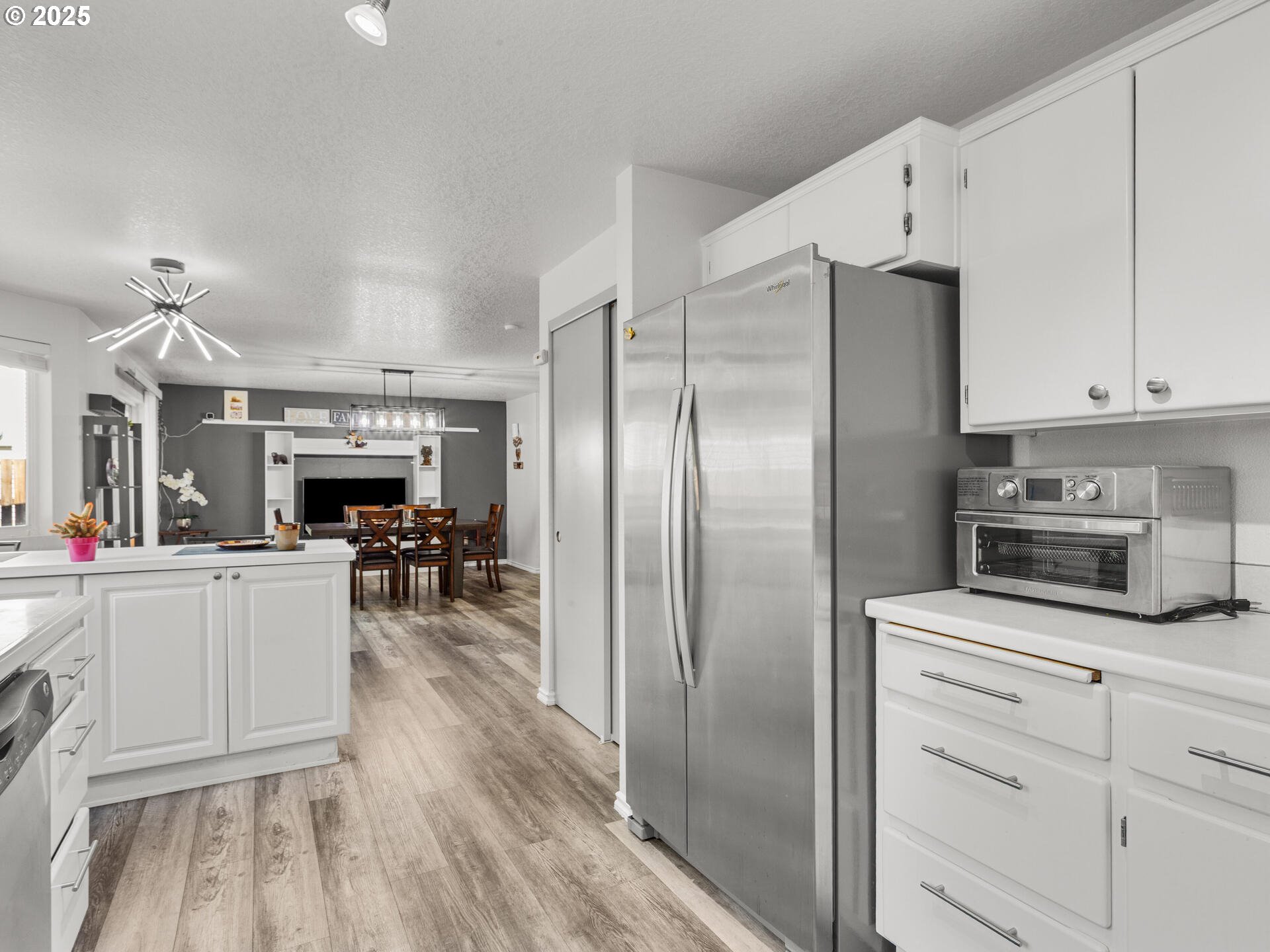 8292 Northeast Snowberry Loop Vancouver, WA 98664 - Photo 24 of 48 a kitchen with refrigerator cabinets and wooden floor
