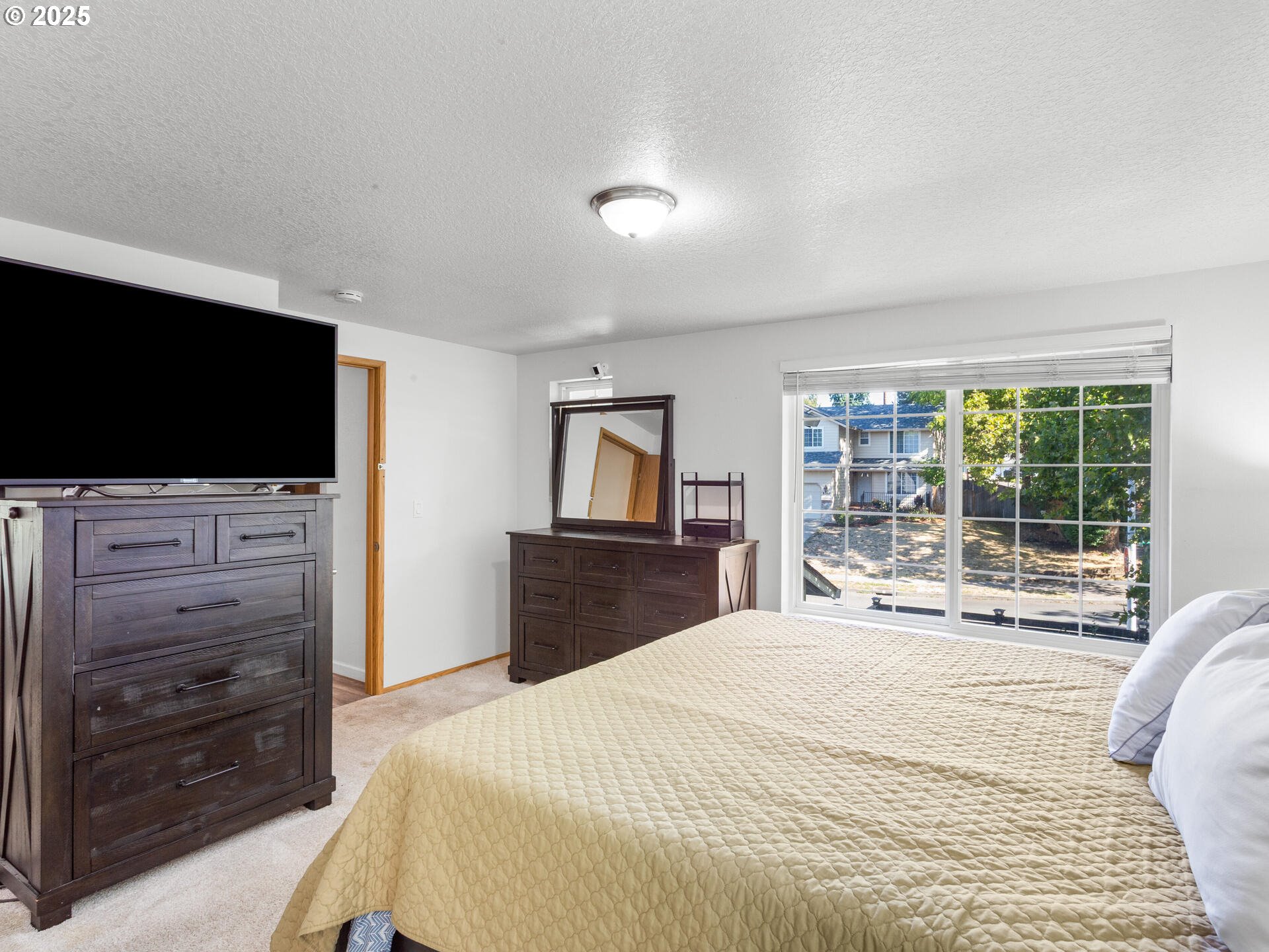 8292 Northeast Snowberry Loop Vancouver, WA 98664 - Photo 30 of 48 a bedroom with a bed and a flat screen tv