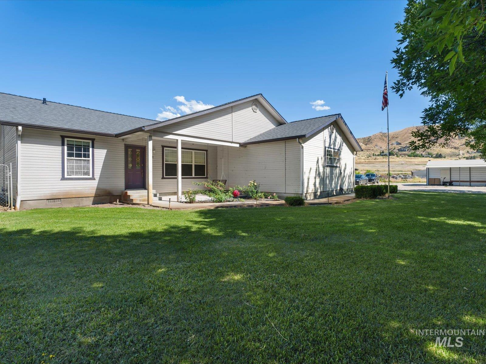 3540 Wills Road Emmett, ID 83617 - Photo 6 of 36 Front exterior featuring light-colored siding, dark trim windows, and a covered porch entry