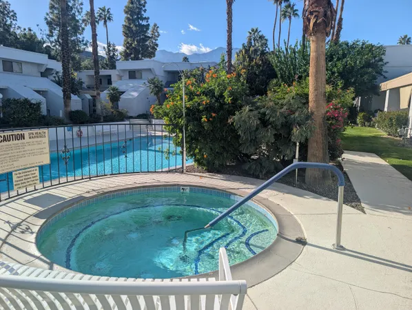 a view of a swimming pool with a patio and plants
