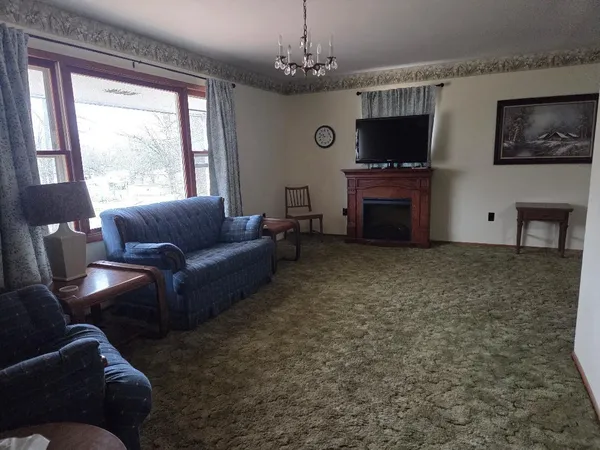 a living room with furniture a flat screen tv and a window