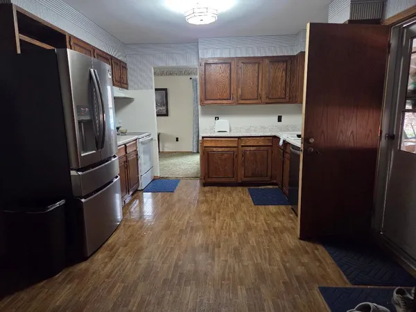 a kitchen with a refrigerator and wooden cabinets