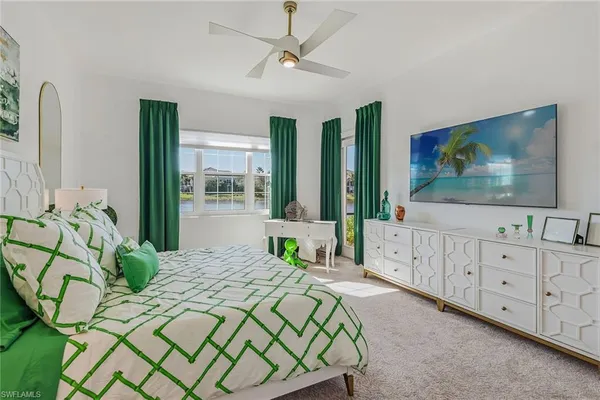 a bedroom with a bed a flat screen tv and dresser