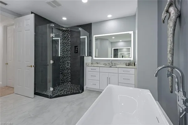 a bathroom with a tub sink and mirror