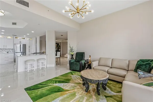 a living room with furniture and a dining table with kitchen view