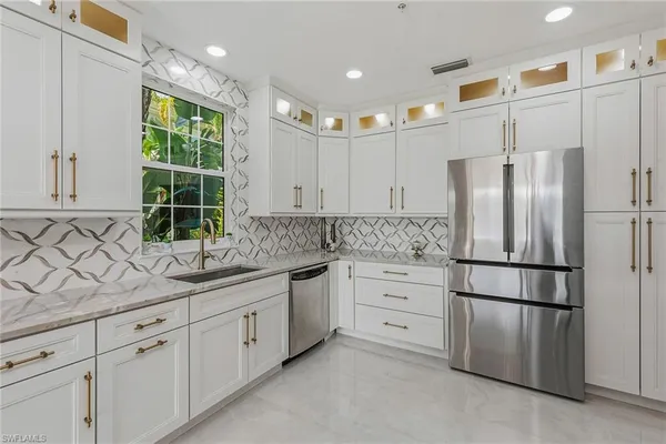 a kitchen with stainless steel appliances granite countertop a refrigerator sink and cabinets