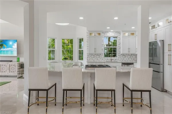 a kitchen with a table chairs refrigerator and cabinets