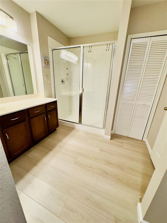 1508 Wild Rye Circle Princeton, TX 75407 - Photo 15 of 17 Bathroom with a closet, vanity, a stall shower, and light wood-style floors