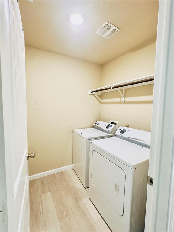 1508 Wild Rye Circle Princeton, TX 75407 - Photo 4 of 17 Laundry area with light wood-style flooring and washer and dryer