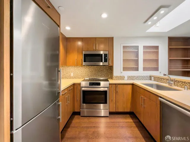 a kitchen with stainless steel appliances granite countertop a stove and a sink