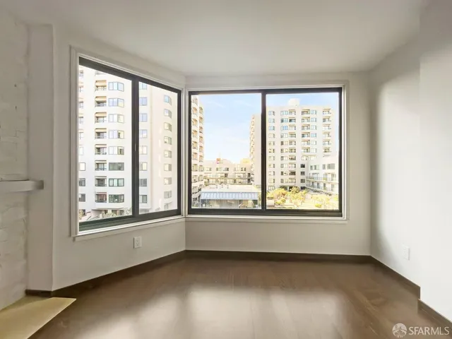 a view of an empty room with a fireplace and a window