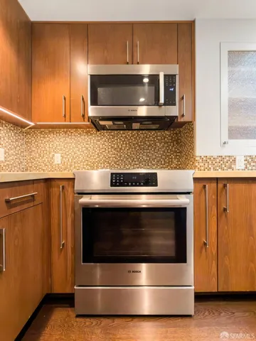 a kitchen with granite countertop a stove and a microwave