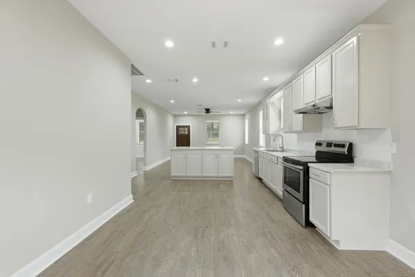 a view of kitchen with sink and refrigerator