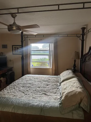 a bedroom with a bed and a refrigerator