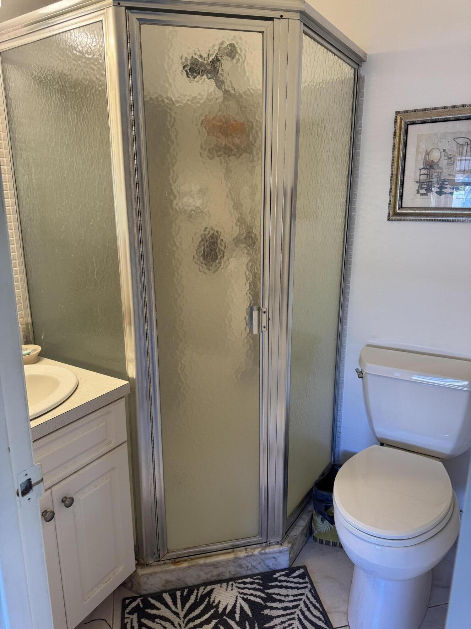 8892 Bella Vista Drive, Unit 333 Boca Raton, FL 33433 - Photo 3 of 18 a bathroom with a toilet and a shower