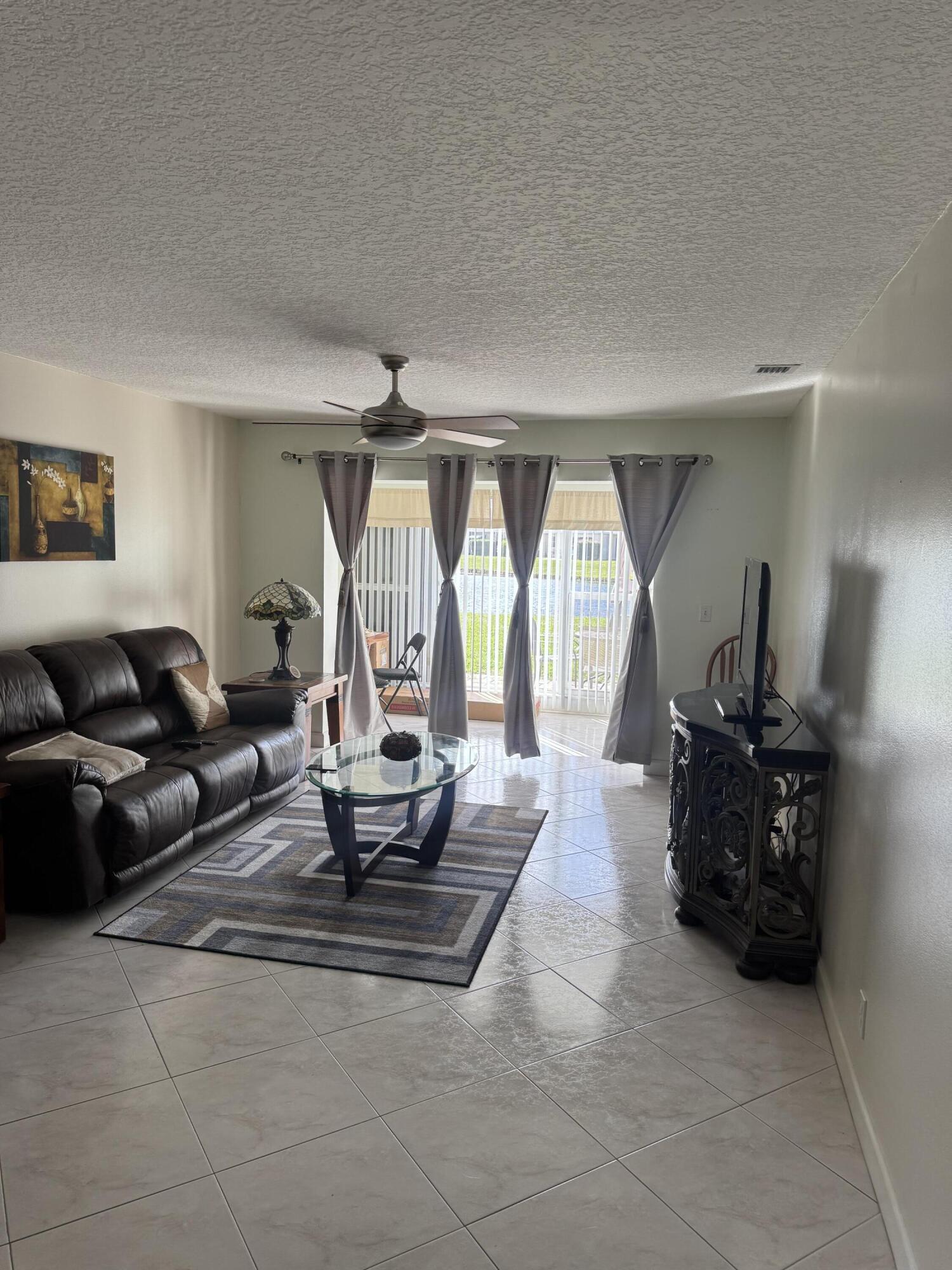 8892 Bella Vista Drive, Unit 333 Boca Raton, FL 33433 - Photo 9 of 18 a living room with furniture and a large window