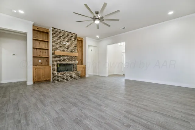 a view of an empty room with a fireplace and a window