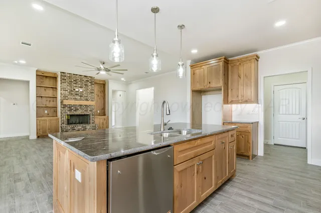 a kitchen with stainless steel appliances granite countertop a sink a stove and a wooden floors