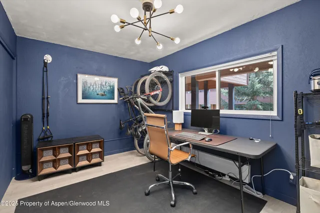 a view of a workspace with furniture and a window