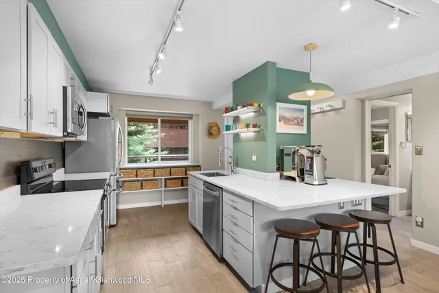 a kitchen with stainless steel appliances kitchen island granite countertop a sink and cabinets