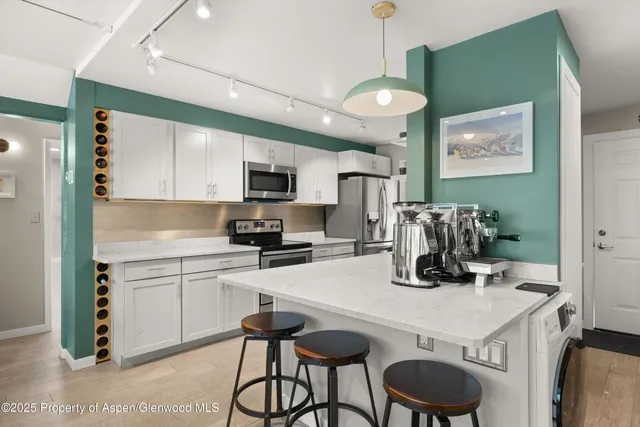 a kitchen with kitchen island a stove a table and chairs in it