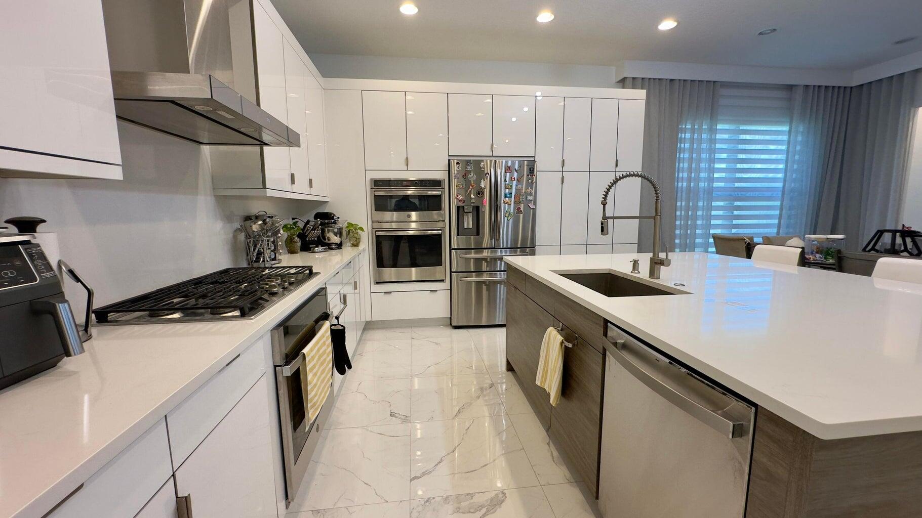 8817 New River Falls Road Boca Raton, FL 33496 - Photo 11 of 54 a kitchen with a sink a stove and cabinets