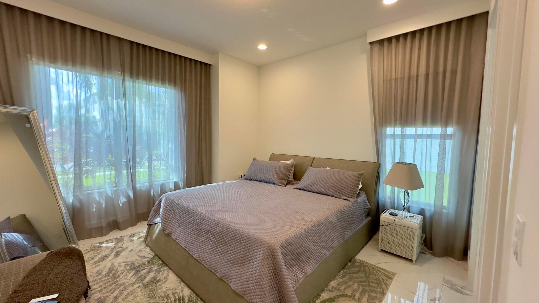 8817 New River Falls Road Boca Raton, FL 33496 - Photo 19 of 54 a bedroom with a bed and glass door