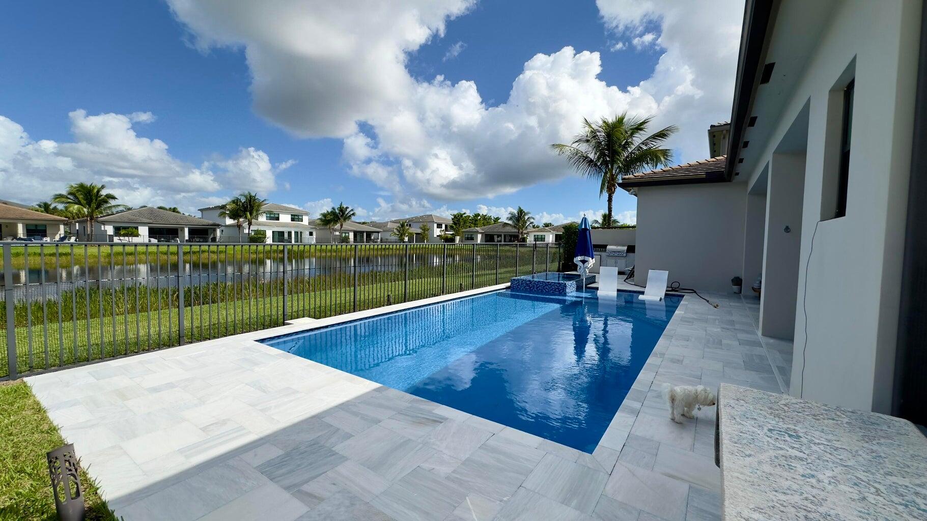 8817 New River Falls Road Boca Raton, FL 33496 - Photo 34 of 54 a view of a swimming pool with a lake in the back