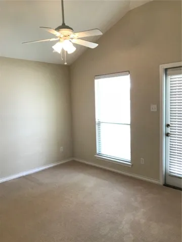 an empty room with a window and a fan