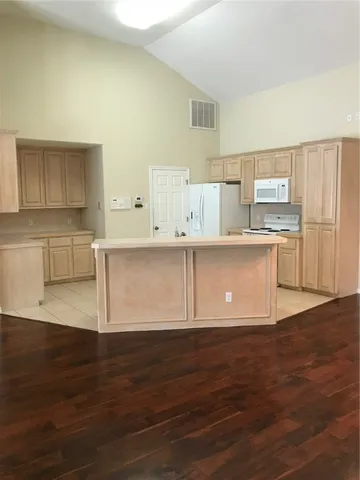 a kitchen with stainless steel appliances granite countertop a sink and a refrigerator
