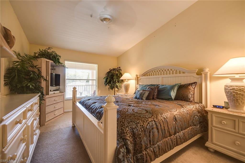 7635 Arbor Lake Court, Unit 2423 Naples, FL 34112 - Photo 16 of 35 a spacious bedroom with a bed and a cabinets