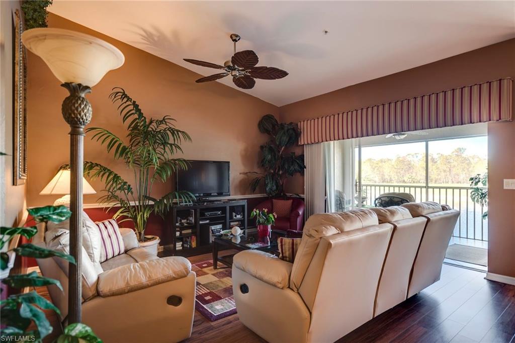 7635 Arbor Lake Court, Unit 2423 Naples, FL 34112 - Photo 4 of 35 a living room with furniture a ceiling fan and a large window