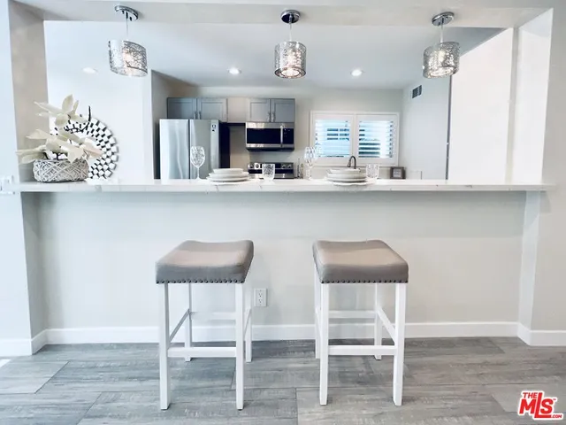a kitchen with cabinets and chairs