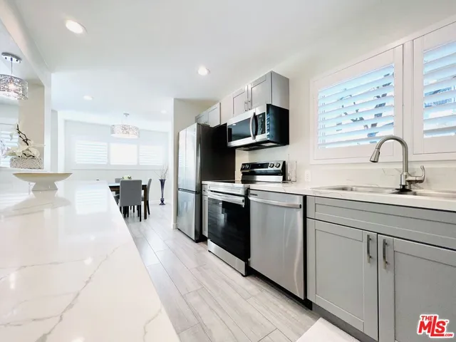 a kitchen with stainless steel appliances kitchen island granite countertop a sink and cabinets