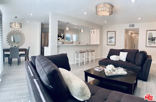 a living room with furniture kitchen view and a table
