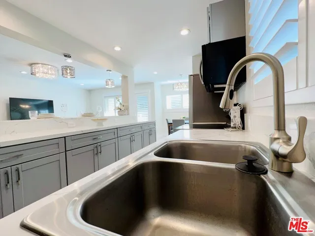 a kitchen with a sink and a stove with wooden floor