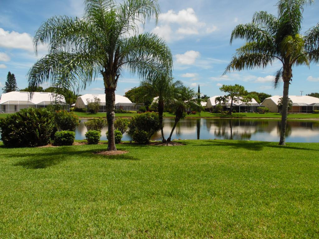 9009 Michael Circle, Unit 109 Naples, FL 34113 - Photo 2 of 18 a view of a garden with a lake