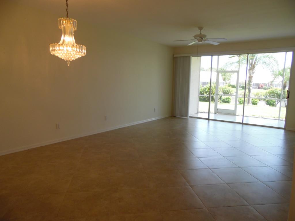 9009 Michael Circle, Unit 109 Naples, FL 34113 - Photo 5 of 18 a view of empty room with wooden floor and fan