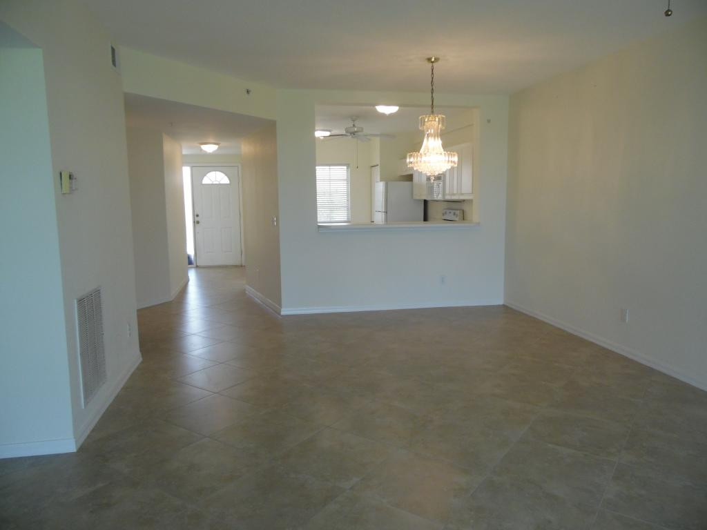 9009 Michael Circle, Unit 109 Naples, FL 34113 - Photo 6 of 18 wooden floor in an empty room with a window