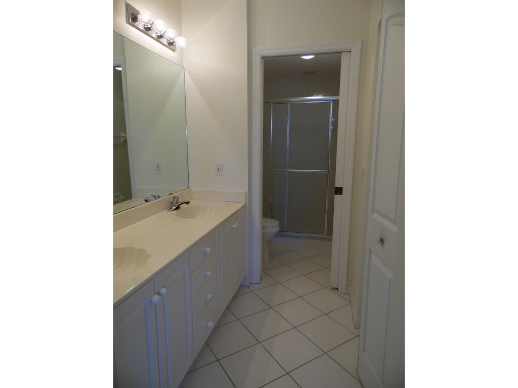 9009 Michael Circle, Unit 109 Naples, FL 34113 - Photo 8 of 18 a spacious bathroom with a shower and a sink