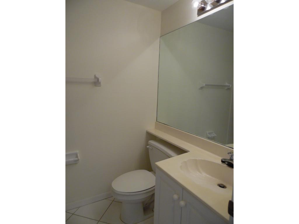 9009 Michael Circle, Unit 109 Naples, FL 34113 - Photo 10 of 18 a bathroom with a sink toilet and vanity