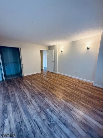 a big room with wooden floor and natural light