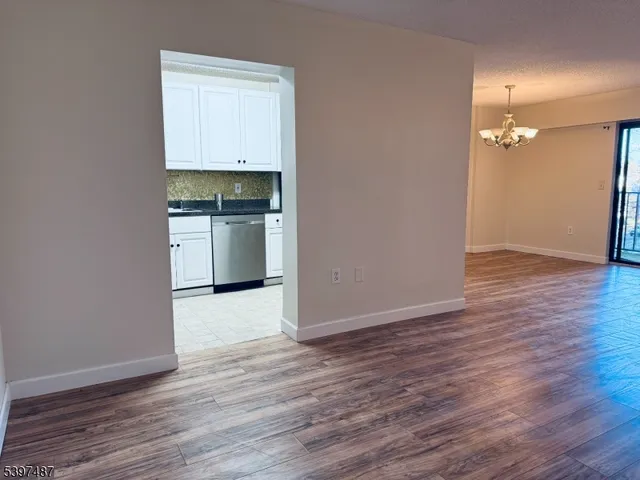 a kitchen with wooden floor and electronic appliances