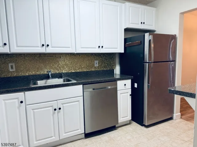 a kitchen with stainless steel appliances white cabinets and a sink