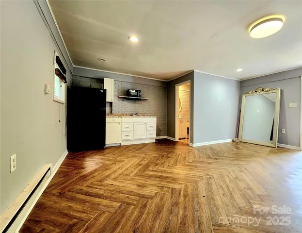 a view of empty room with wooden floor