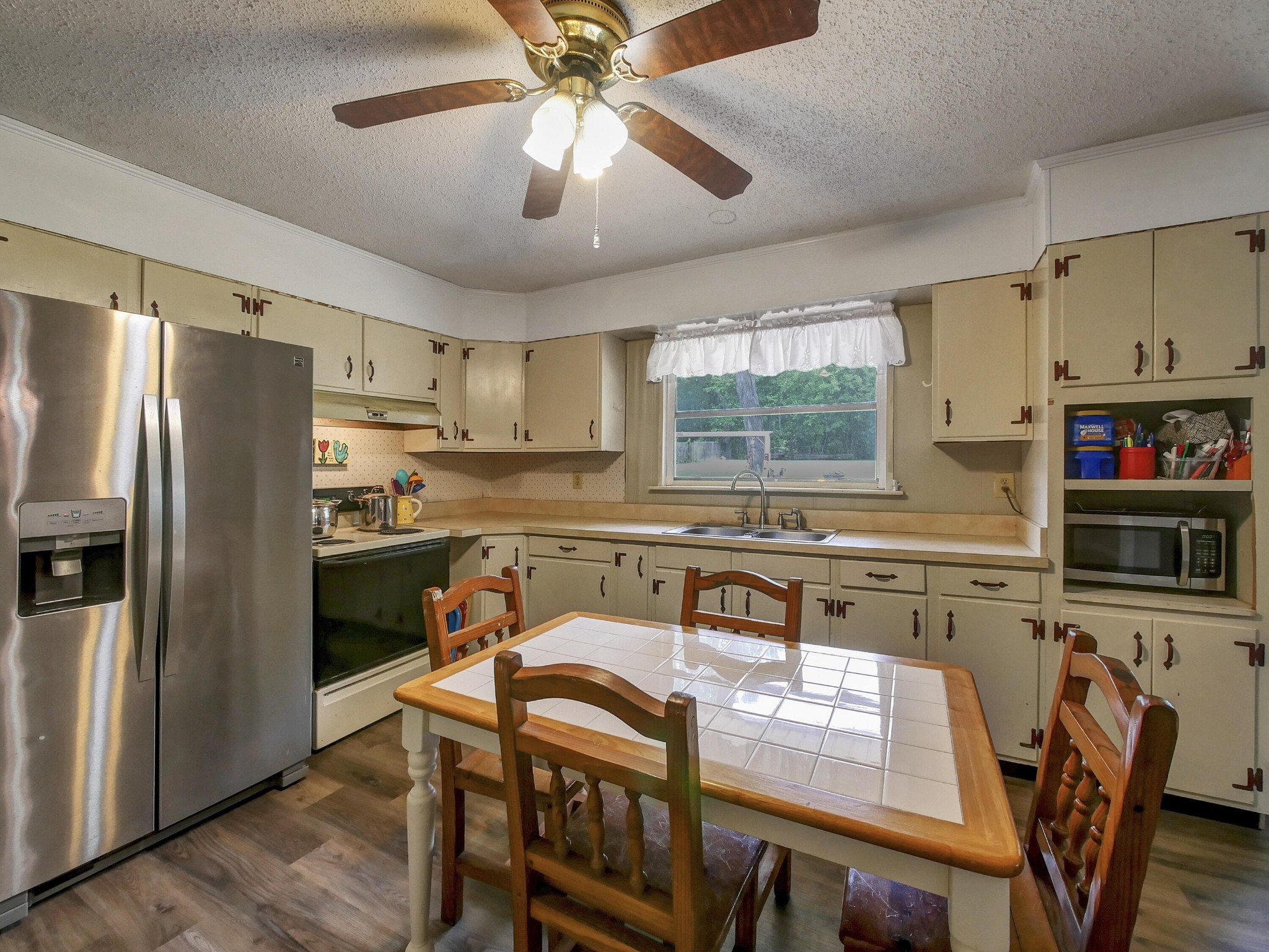 902 Lindsay Avenue Chattanooga, TN 37421 - Photo 13 of 29 a kitchen with stainless steel appliances granite countertop a refrigerator a stove a sink a dining table and chairs with wooden floor