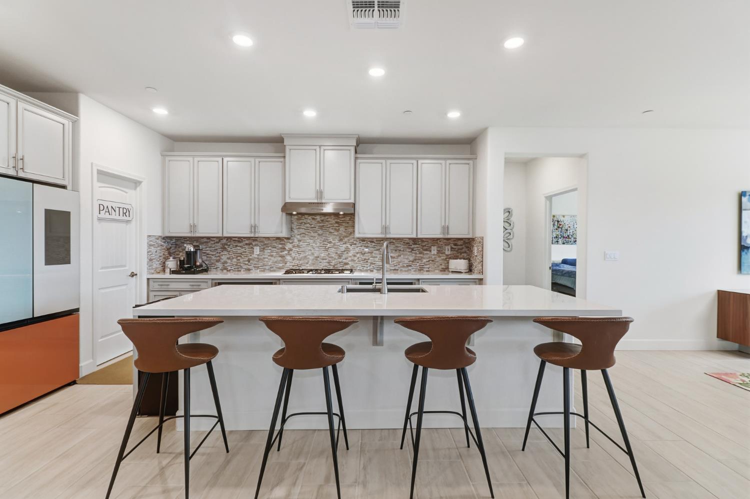 5321 Fandango Loop Roseville, CA 95747 - Photo 7 of 38 a kitchen with stainless steel appliances granite countertop a stove a sink a island with chairs and white cabinets