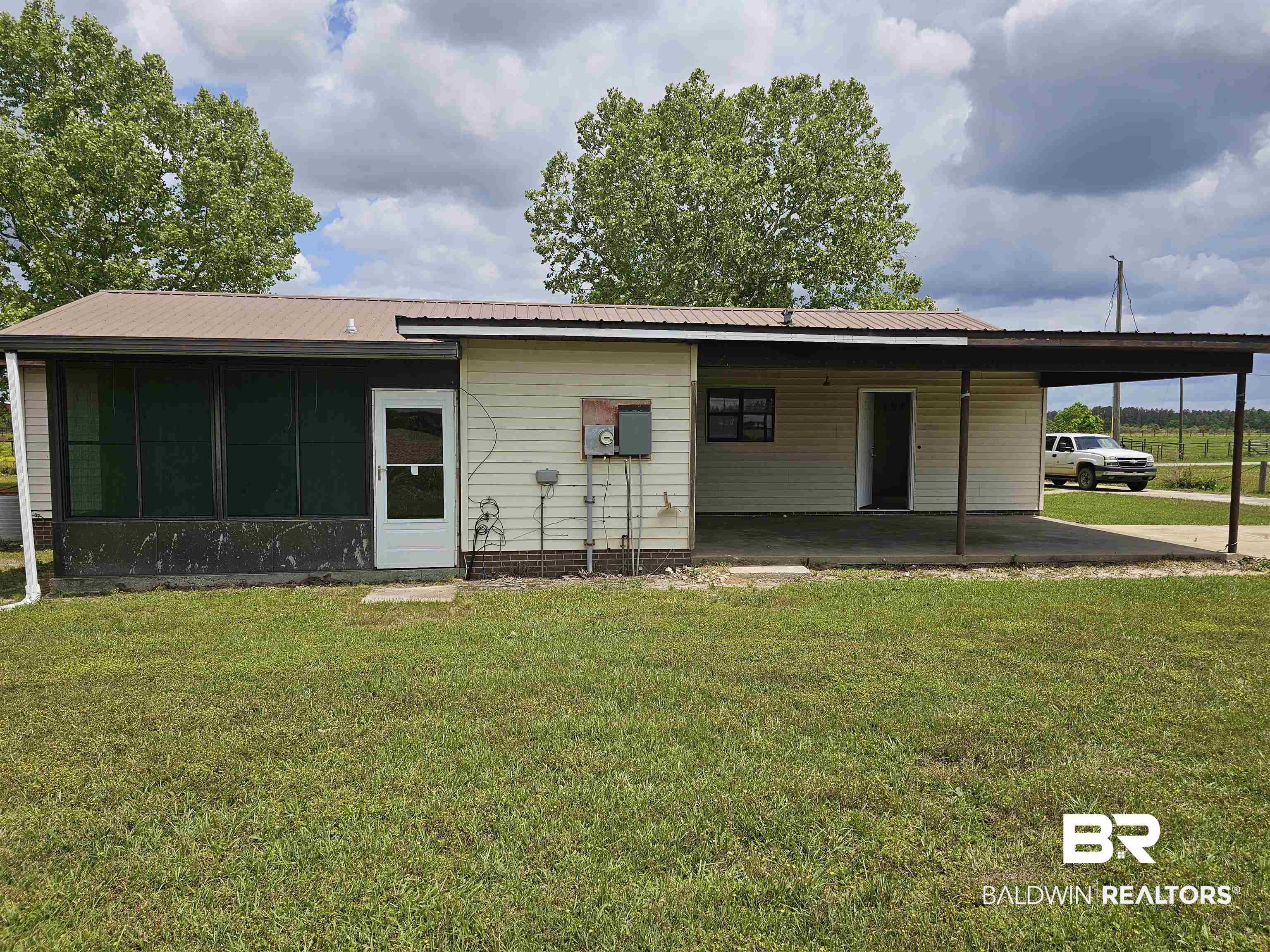 59575 Lottie Road Atmore, AL 36502 - Photo 4 of 23 Back of house featuring a yard, a sunroom, and a carport