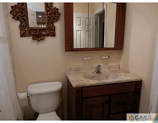 43 Poplar Road Piscataway, NJ 08854 - Photo 17 of 21 a bathroom with a toilet sink and mirror