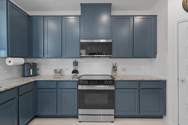 a kitchen with granite countertop cabinets stainless steel appliances and a sink